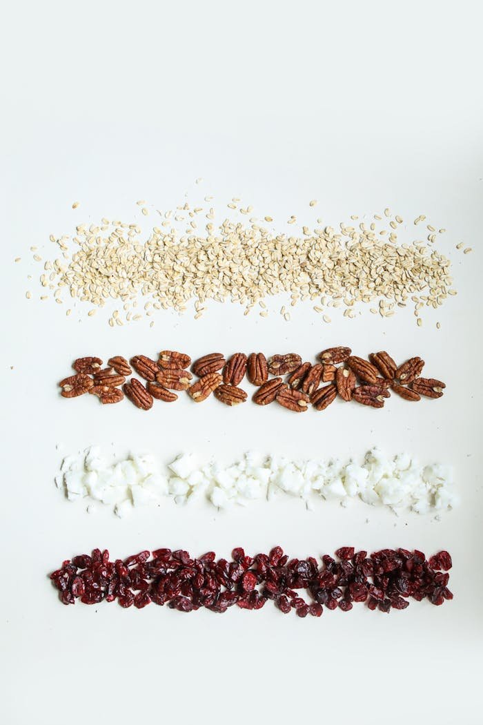 Flat lay of oats, pecans, coconut flakes, and cranberries.